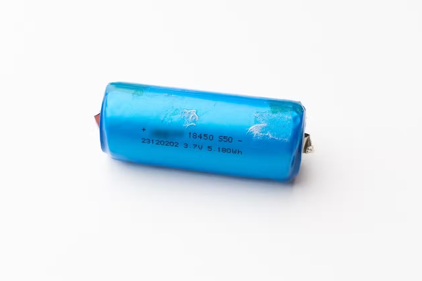 A close up photo of a blue lithium battery from a vape