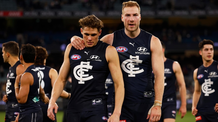 Charlie Curnow and Harry McKay walk over the field together after Carlton's loss to Collingwood in the 2022 AFL season.
