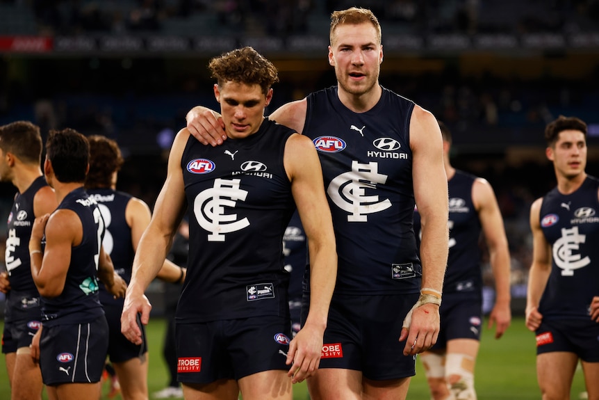 Charlie Curnow and Harry McKay walk over the field together after Carlton's loss to Collingwood in the 2022 AFL season.