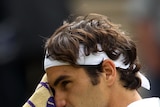 Federer wipes his face with a towel
