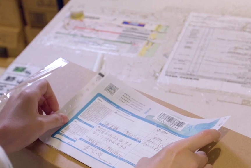 A daigou sticks a label with logistics information on to a parcel.