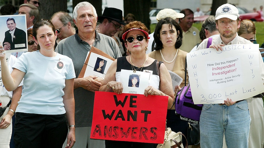 Family members of 9/11 victims hold posters and pictures of their loved ones at a rally on Capital Hill in Washington