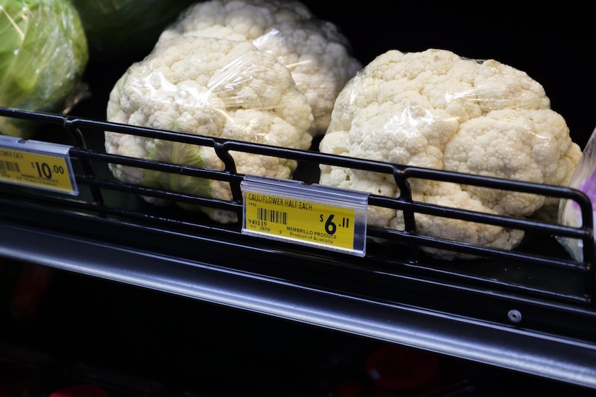 Cauliflower on a supermarket shelf with the price at six dollars for one half 