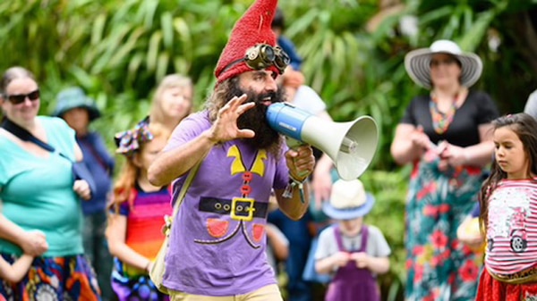Man dressed as a garden gnome with a loudspeaker.