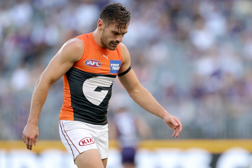 A GWS Giants AFL player looks down at the ground during a match against Fremantle in Perth.
