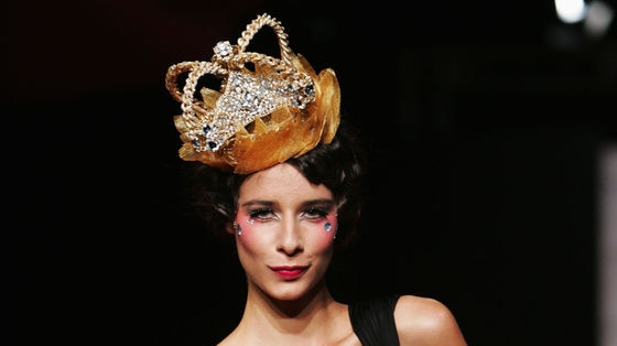 A model wears a Ruth Tarvydas's black dress and crown on the runway