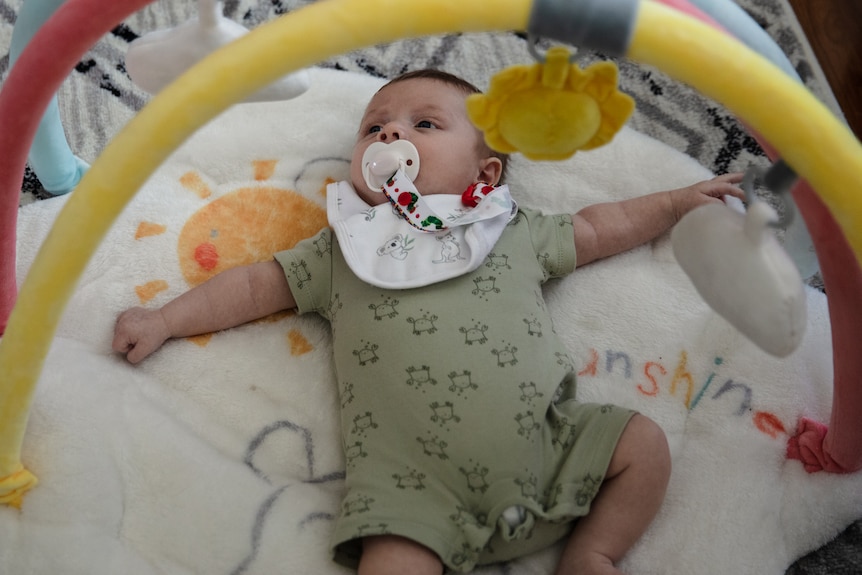 Baby lying on a play mat