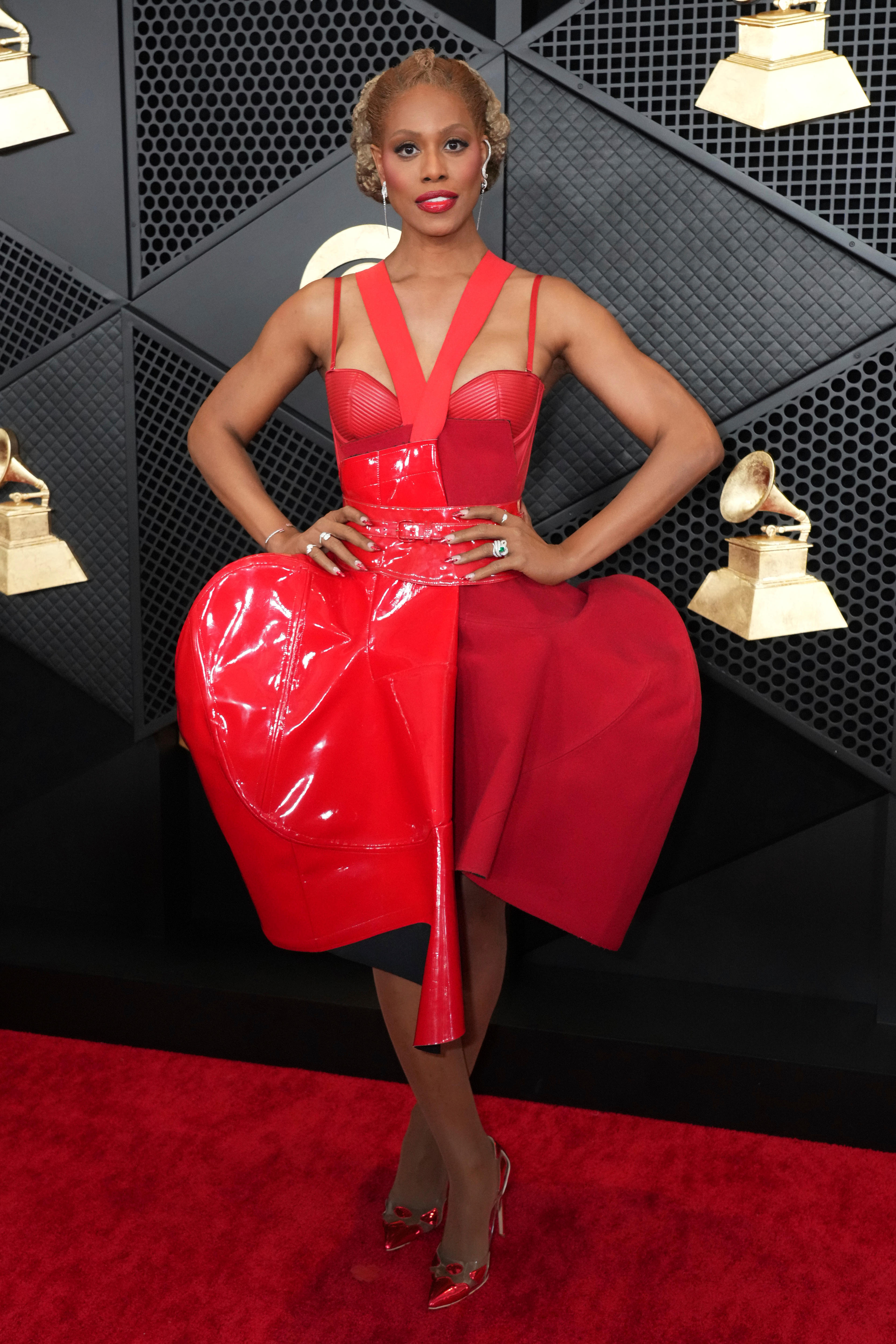 Laverne Cox wearing a red strappy mini dress with curved boning propping up the skirt