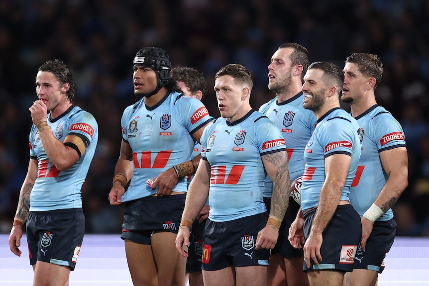 A group of rugby league players look sad after conceding a try 