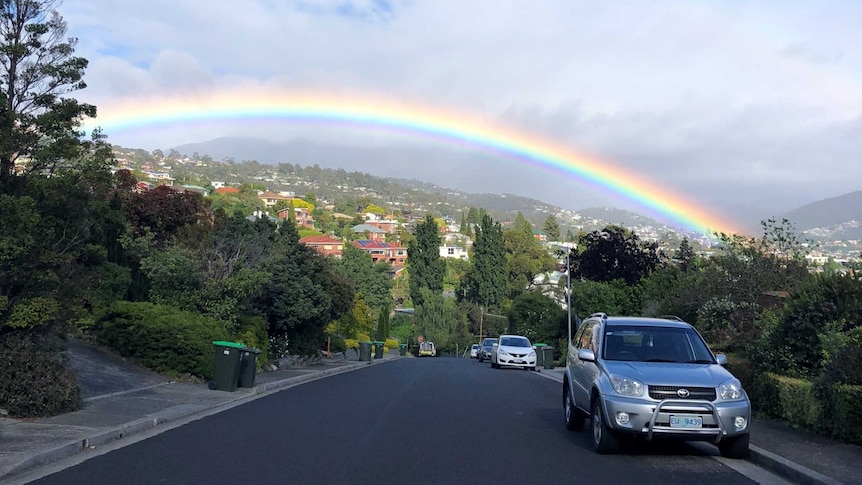 A rainbow at the top of a street