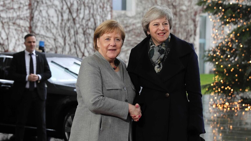British Prime Minister Theresa May smiles at the cameras as she is greeted by German Chancellor Angela Merkel