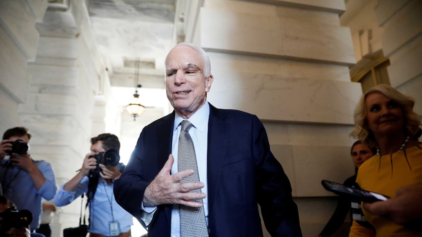 Senator John McCain leaves the Senate in a suit with a notable scar above his left eye
