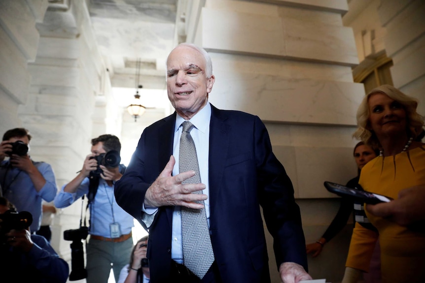 Senator John McCain leaves the Senate in a suit with a notable scar above his left eye