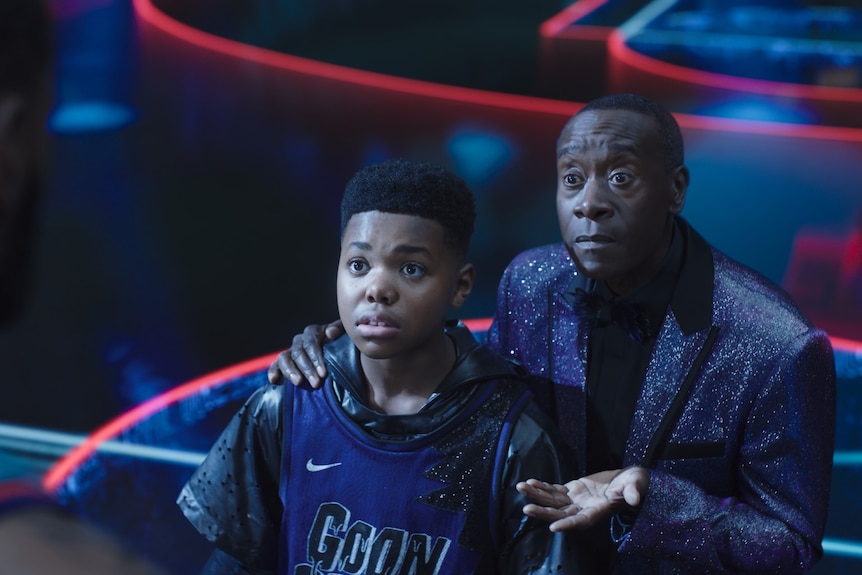 LeBron James looks down at his Cedric Joe as his son and Don Cheadle who has his hand on Cedric's shoulder