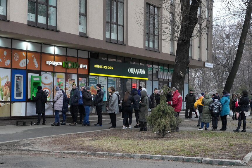 Queues of people line up to withdraw money from ATMs in Kyiv, Ukraine.