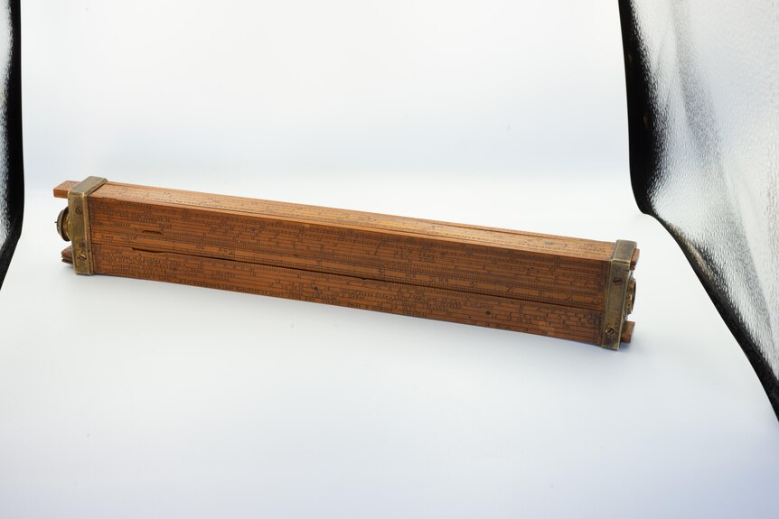 A wooden ruler with separate parts that slide out and metal tips.