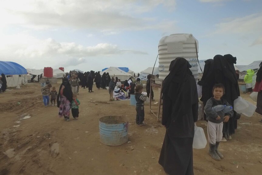 Women and children line up for water at al-Hawl