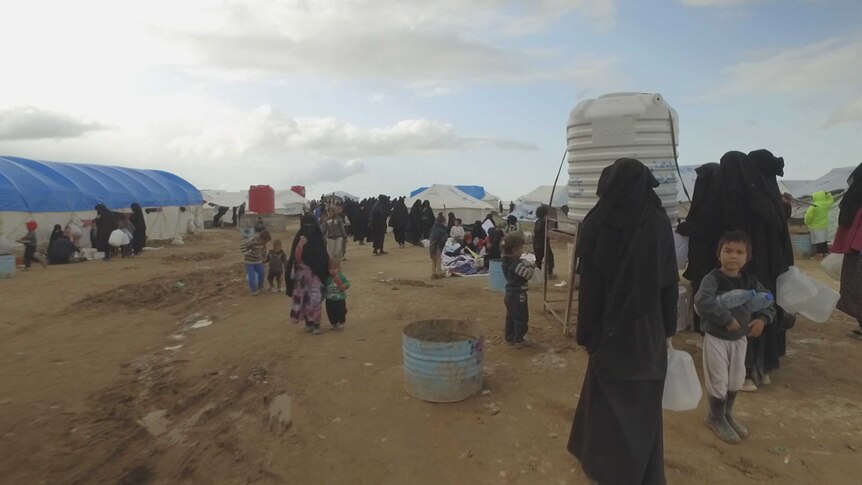 Women and children line up for water at al-Hawl