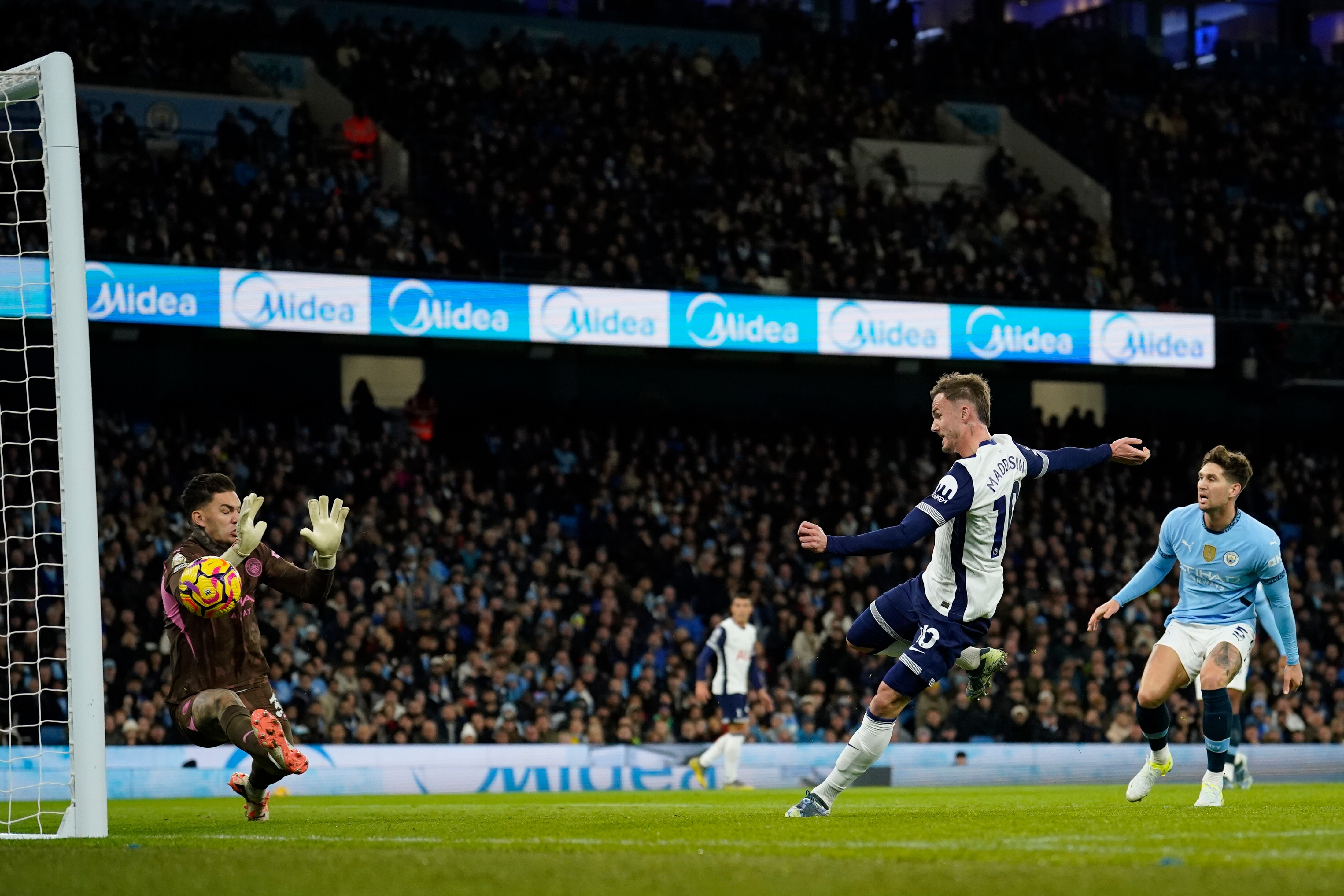 A Spurs forward turns his body as he blasts the ball past the Manchester City goalkeeper into the net.