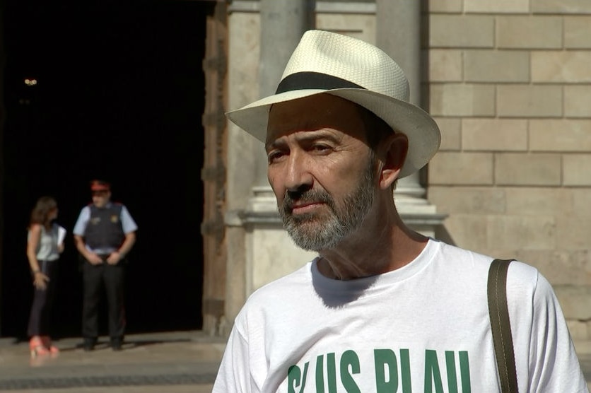 Retired journalist Cesar Lopez stands in Barcelona's historic Sant Jaume Square.