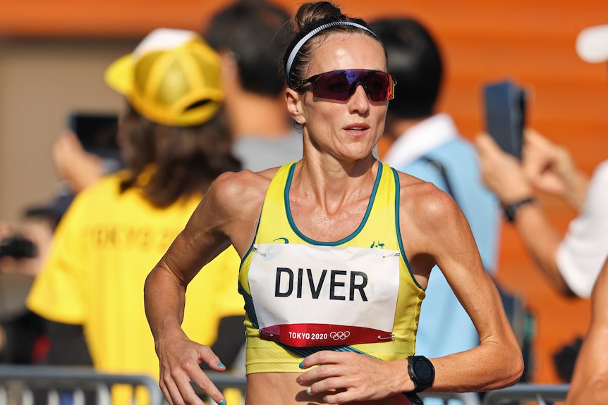 Sinead Diver runs wearing sunglasses and a crop top with 'DIVER' written on a pinned piece of paper