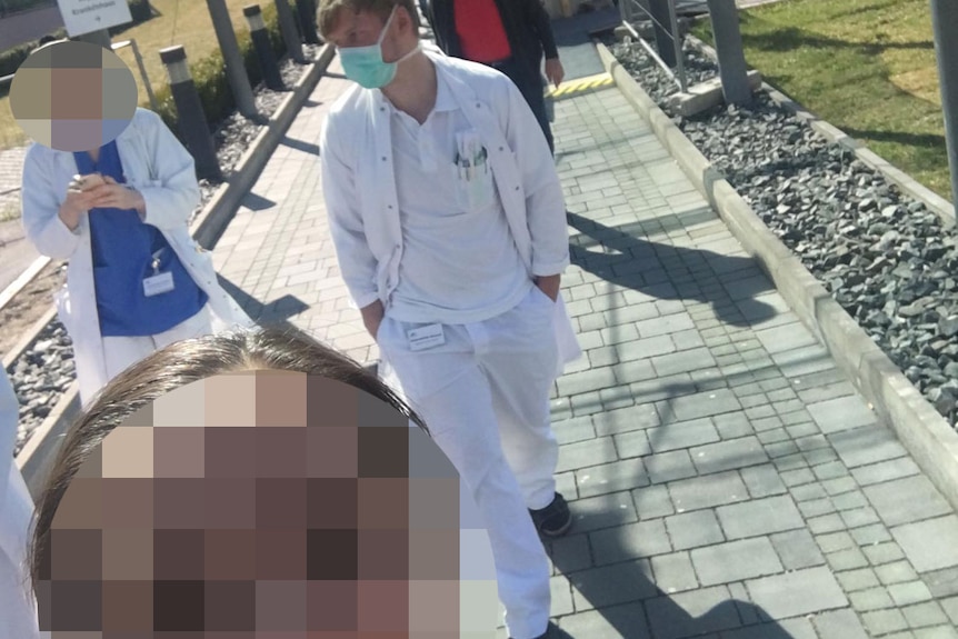 A doctor whose face is blurred, takes a selfie outside a hospital in Austria during the coronavirus COVID-19 pandemic.