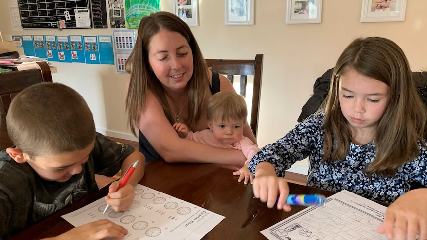 Sarah Praag sits at a table with her children Lincoln, Hailey and Millie.