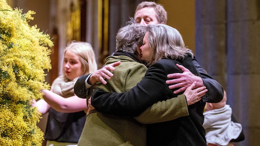 Grieving relatives embrace at the MH17 memorial service in Melbourne