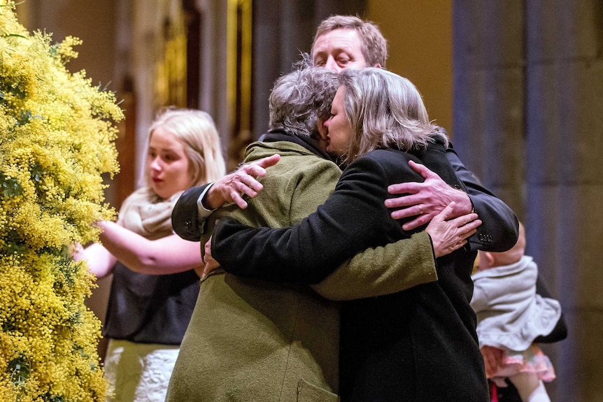 Grieving relatives embrace at the MH17 memorial service in Melbourne