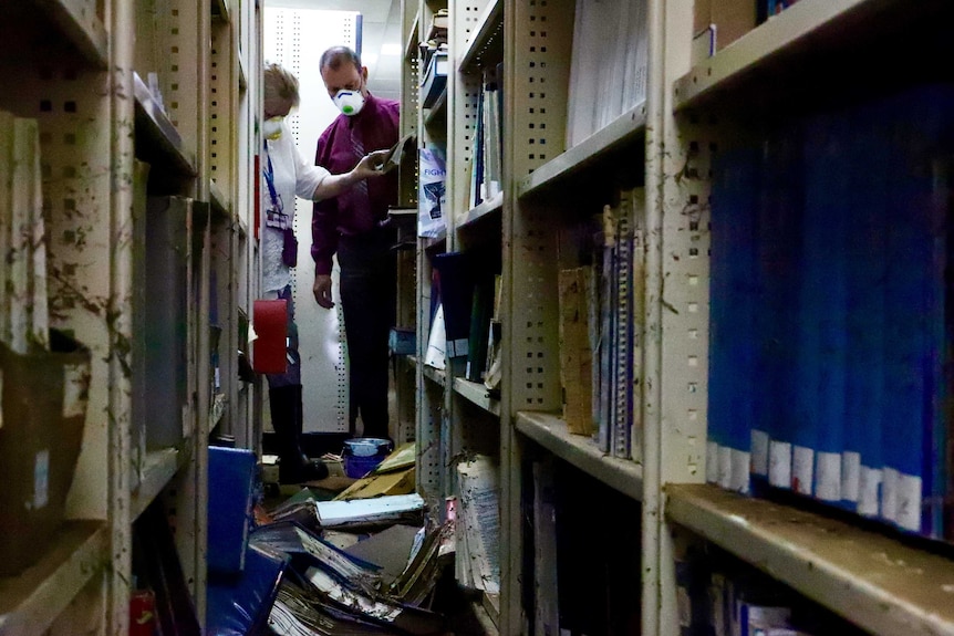 Librarians sort through damaged books still on their shelves.