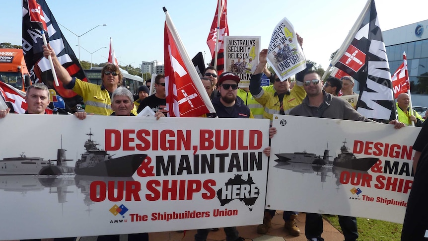 Waving flags and signs, AMWU union members protest outside defence minister's office