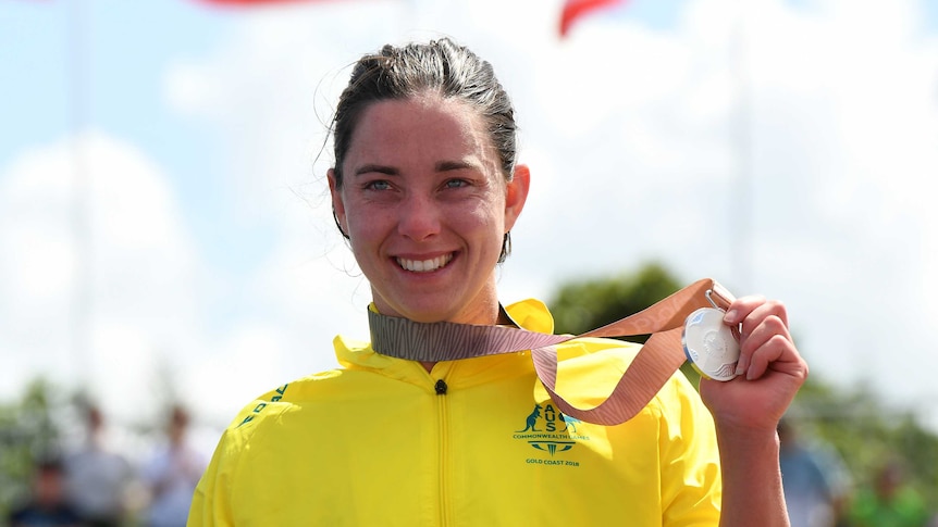 Emily Tapp holds up her silver medal.