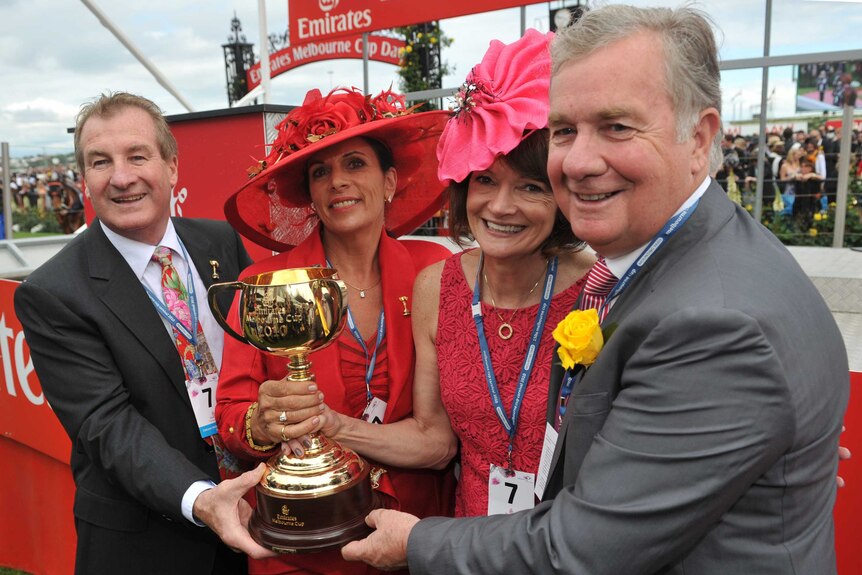 Co-owner of Melbourne Cup winning horse Americain Gerry Ryan celebrates as he holds the trophy at Flemington Racecourse in 2010.