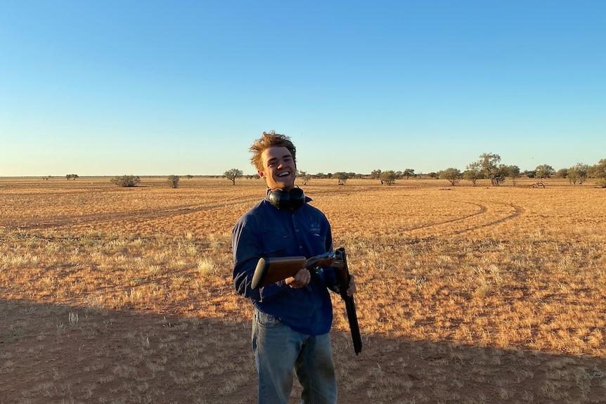 Young man on outback property loads rifle