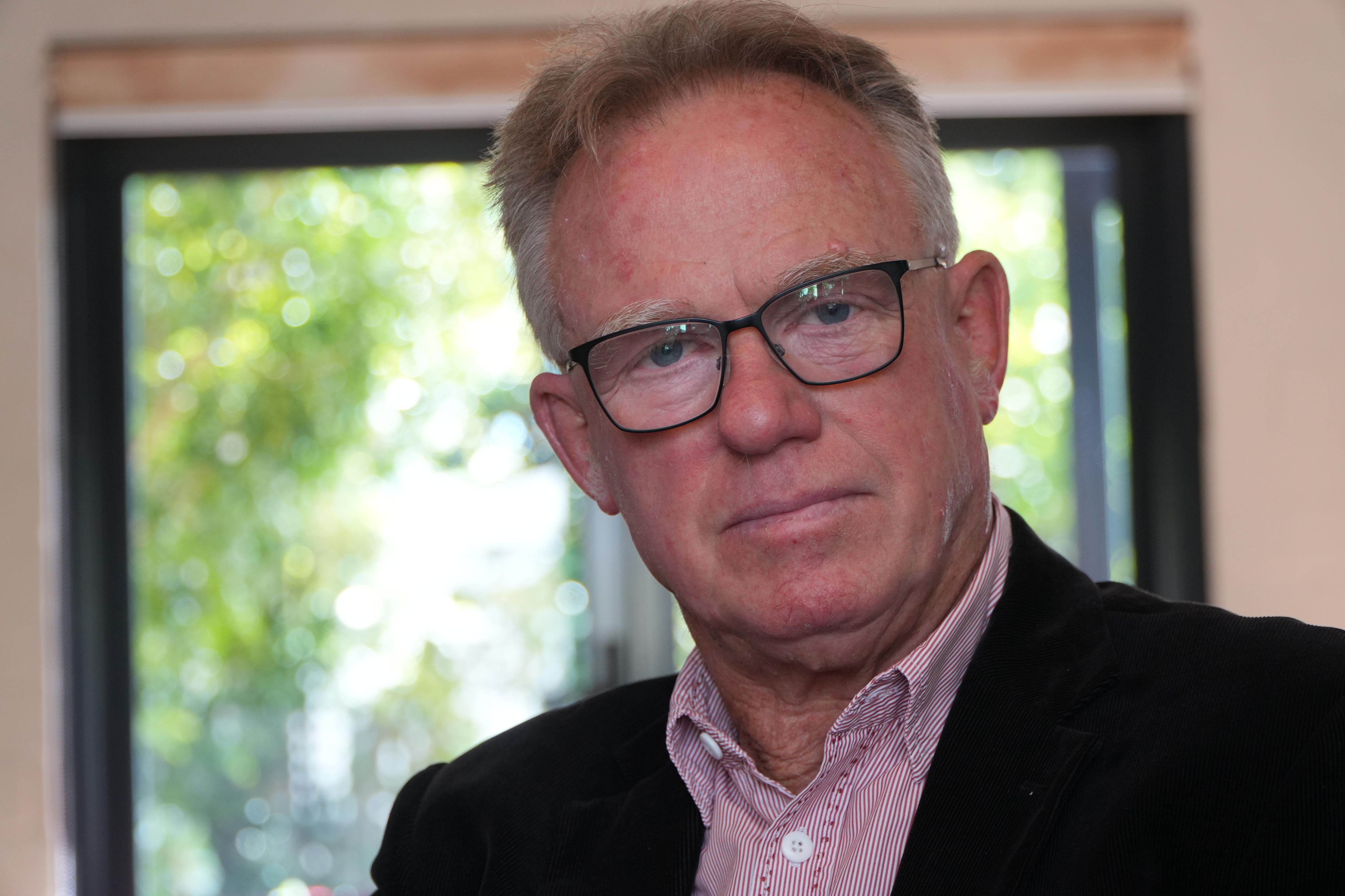 A tight head and shoulders shot of former state Labour MP Martin Whitely indoors, wearing a dark suit jacket and pink shirt.