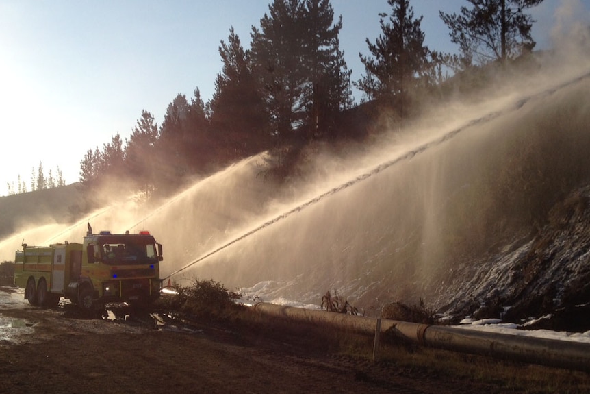 Fire truck sends streams of water onto the coal batter or rock face at Hazelwood mine