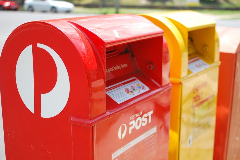 Australia Post mail boxes stand by the side of the road.