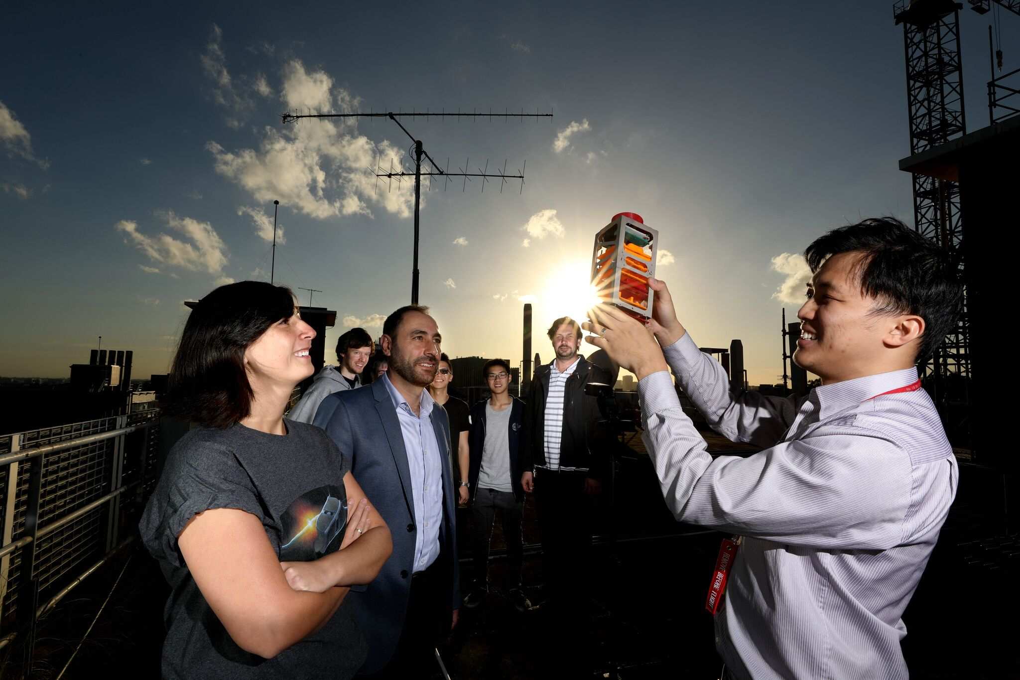 six scientists looking at an object shaped like a lantern.