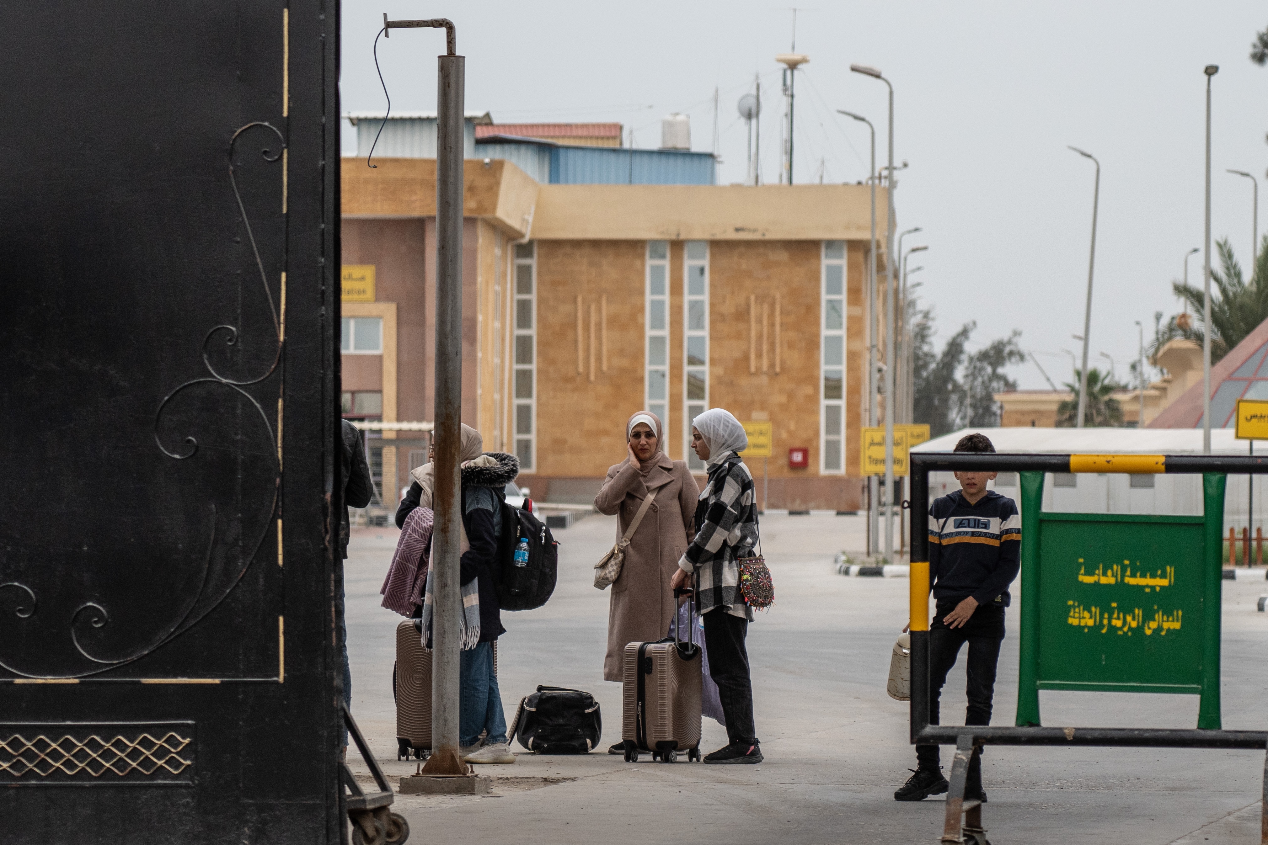 A family is checked by an official near a truck.