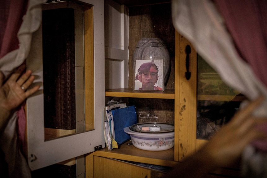 A photo of a young man displayed in a kitchen cabinet