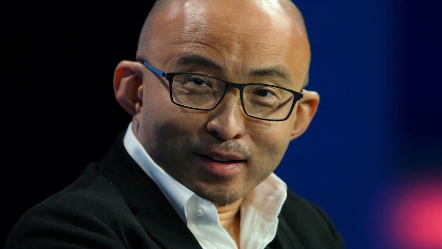 A bald chinese man with square glasses