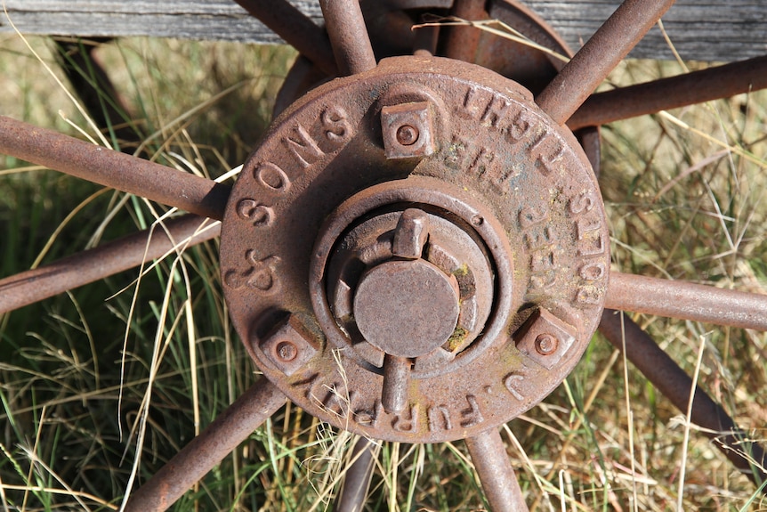 A close up of a cast iron wheel of a cart