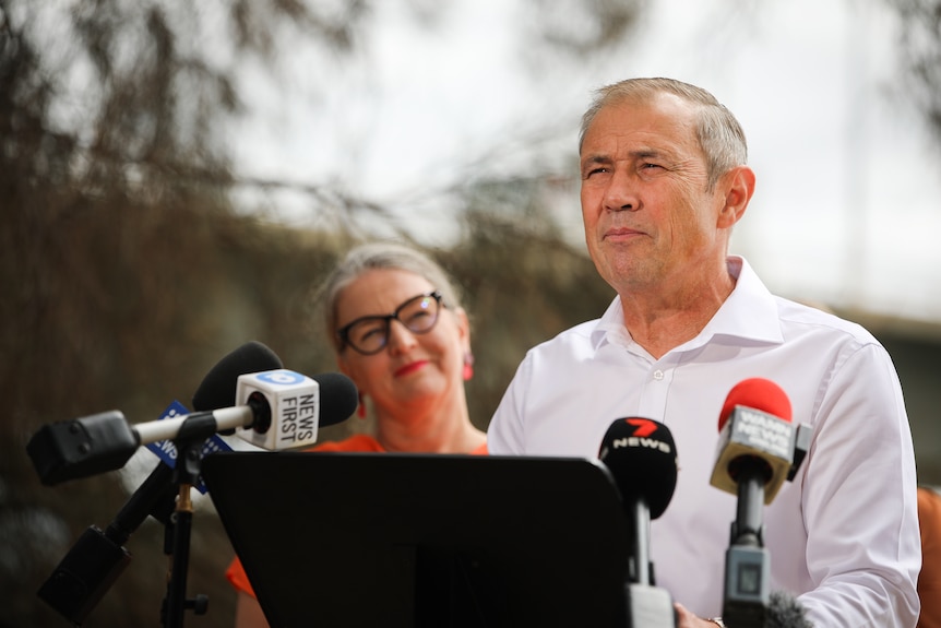 Premier Roger Cook speaking to the media behind a podium