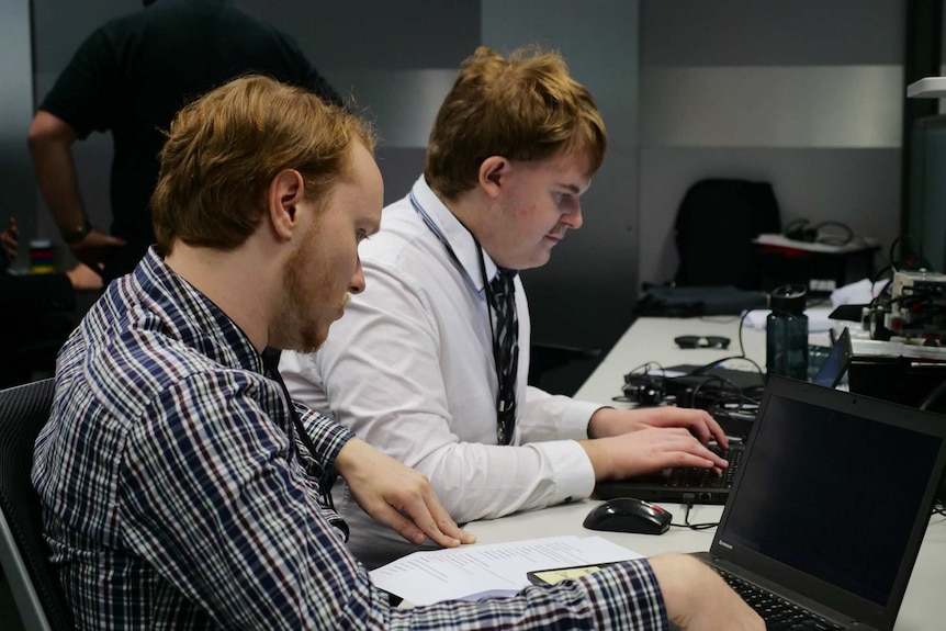 Two men working on their laptops.