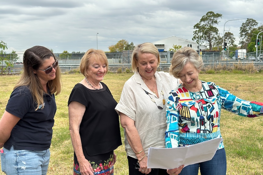 Group of women look at plans for homes. 