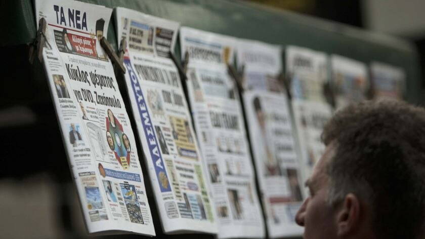 A man reads front page headlines
