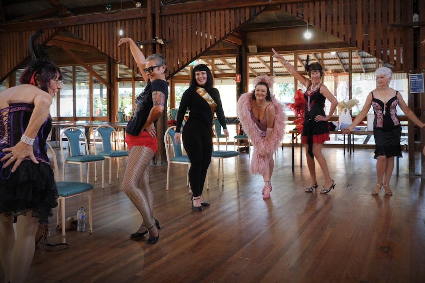 Dressed in feathers, high heals, fishnets and satin, these women strike a pose in their dance hall.