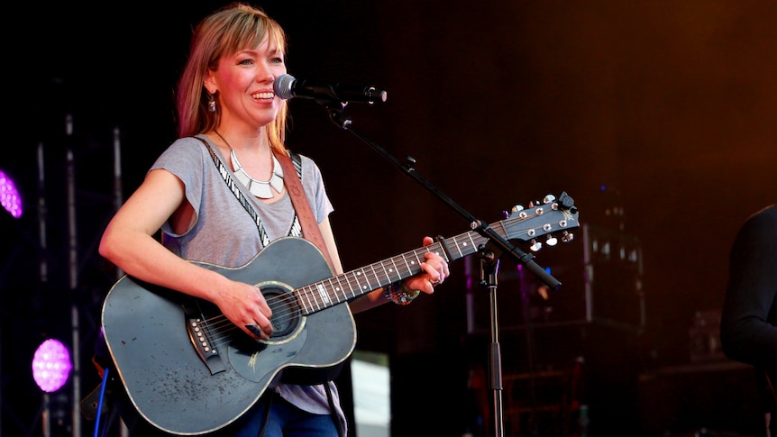 Felicity Urquhart holds a black guitar on stage at the Gympie Muster in 2015.