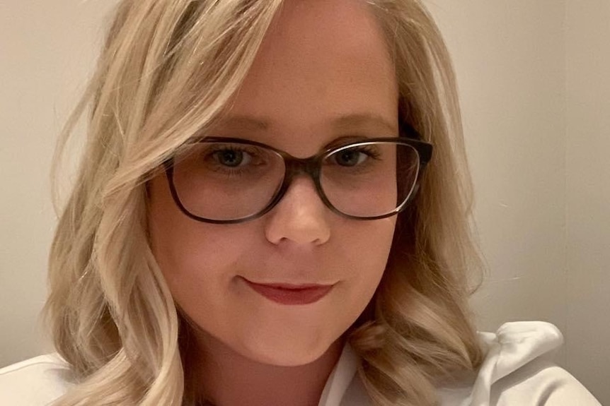 Headshot selfie of a woung woman wearing glasses