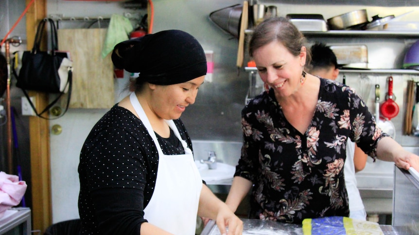 Kirsten Singleton and Gulsum Haider cook in a kitchen